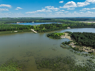 Lake District  swallow hole flooded as a result of the mining damage Pomorzany mine in Olkusz,Poland. Aerial drone view of flooded sand pit. Forest submerged in a lake. Sunken sandpit with clear water