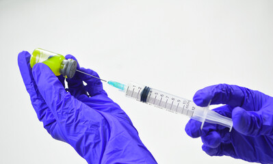 Close up doctor's hand holding medicine bottle and syringe for vaccine to patient on white...