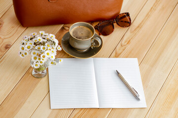 Elegant composition with daisy flowers and women's bag on wooden table with cozy background. Copy space for text or product. Mother's Day, Women's Day, birthday greeting or spring design project card.