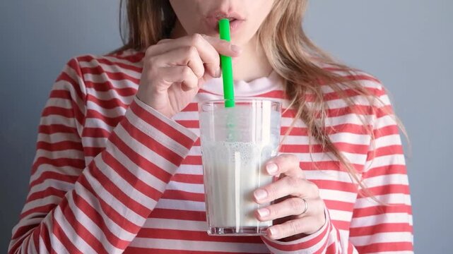 happy dreaming woman drinking homemade banana milkshake, front view