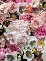 Blumen der Trauer im Trauerkranz in rosa Farben mit Pfingstrosen im Frühling auf dem Friedhof 