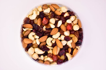Assorted nuts in a round plate on a white background. Flat lay.
