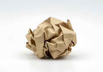 A crumpled brown paper ball on a white surface with shadows and a plain background in studio lighting