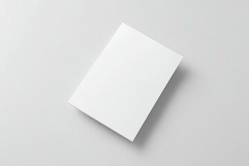 create clean image of minimalistic flyer or brochure mockup lying flat on plain light-colored background with ample