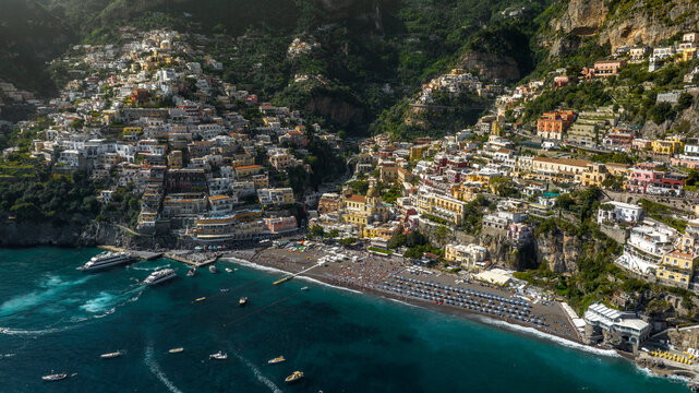 Aerial view of the beach and the city of Positano in the province of Salerno, Campania, Italy. The colorful houses of the town overlook the Mediterranean Sea. It is a beautiful tourist destination.