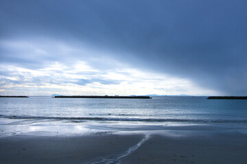 Obraz premium 早朝の砂浜海岸の打ち寄せる波