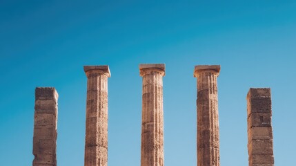 Fototapeta premium minimalistic image of lone ancient university facade with weathered stone columns against clear blue sky on bright