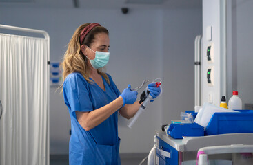 Nurse preparing iv drip in hospital room