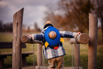 Child Crossing Rope Bridge with Rocket Backpack