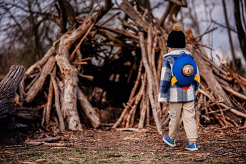 Child Exploring Wooden Stick Fort in Forest