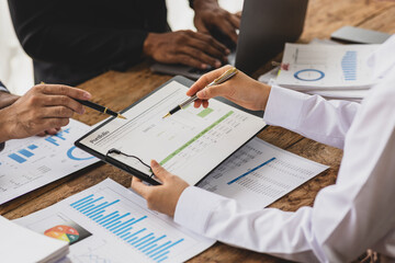 Business professional is working together, analyzing financial chart and graph on desk during a meeting. Analysis business situations and planning investment strategies.
