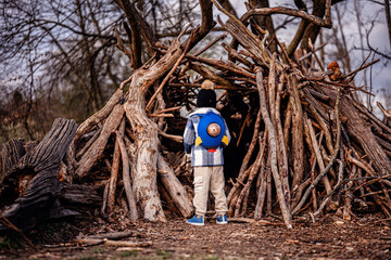 Child Exploring Wooden Stick Fort in Forest