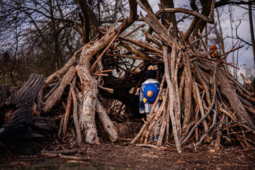 Child Exploring Wooden Stick Fort in Forest