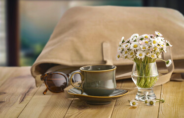 Elegant composition with daisy flowers and women's bag on wooden table with cozy background. Copy space for text or product. Mother's Day, Women's Day, birthday greeting or spring design project card.