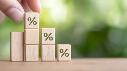 Hand Placing Wooden Percentage Blocks in Ascending Order Against a Blurred Green Background