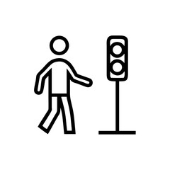 Pedestrian walking past a traffic light during the day in an urban setting