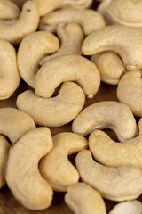 cashew are scattered on a board, cashew are healthy and allowed for vegans. close up