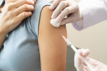 People getting a vaccination to prevent pandemic concept. Woman in medical face mask  receiving a dose of immunization coronavirus vaccine from a nurse at the medical center hospital
