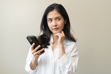 Anxiety Asian woman holding a smartphone and thinking about fake news in app.