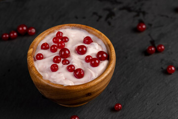 milk product with the addition of red sweet and sour currants and currant flavor, closeup, side view