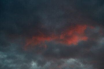 Close-up of gloomy clouds with bloody highlights—a metaphor for inner turmoil, emotional tension. Used in psychological materials about stress.