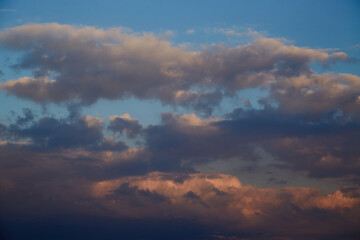The evening sun paints cumulus clouds in warm orange-pink tones. This shot symbolizes completion, peace, and harmony. Suitable for themes of sunsets, love, and goodbyes.