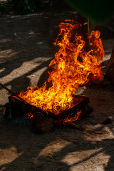 ogromne płomienie podczas procesu wypalania toksycznego oleju z orzechów nerkowca na prowizorycznym palenisku i metalowej podkładce.  © Kamil_k2p