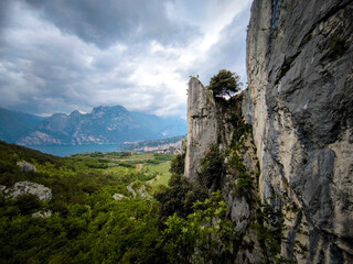 Fototapeta premium View From The Nago Climbing Base Camp In Italy, Overlooking The Garda Lake With Rocky Cliffs And Lush Greenery
