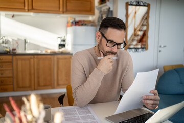 Focused entrepreneur reading documents and working from home office