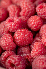 fresh raspberries on the table, the collected amount of ripe raspberries is red closeup