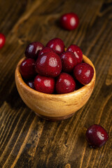 cherry berries in drops of water, wet red cherry fruits on the kitchen table, side view