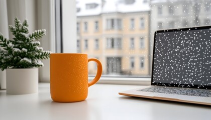 Cozy winter scene orange mug, laptop, snowy window view