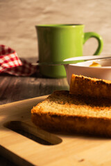 Toasted sliced bread with butter and coffee mug for breakfast
