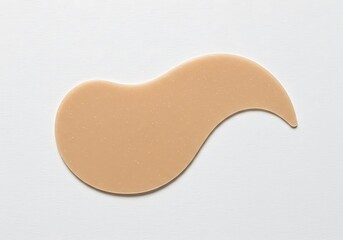 Obraz premium A tan colored silicone patch with a curved shape isolated on a white surface in a studio shot