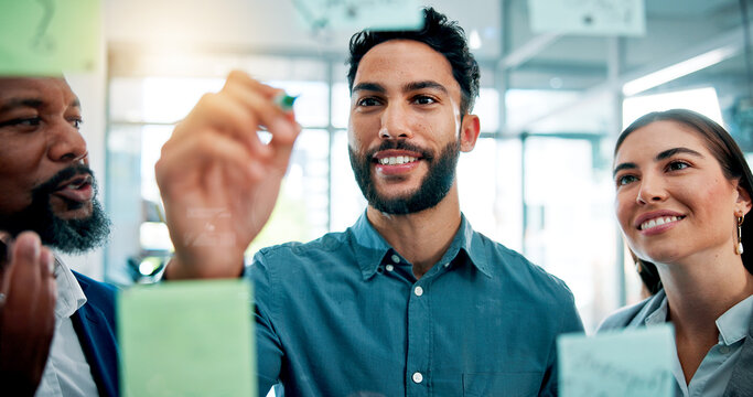 Writing, ideas and business people at glass wall with collaboration, sticky note or brainstorming in office. Teamwork, problem solving and planning at moodboard for growth, development and discussion