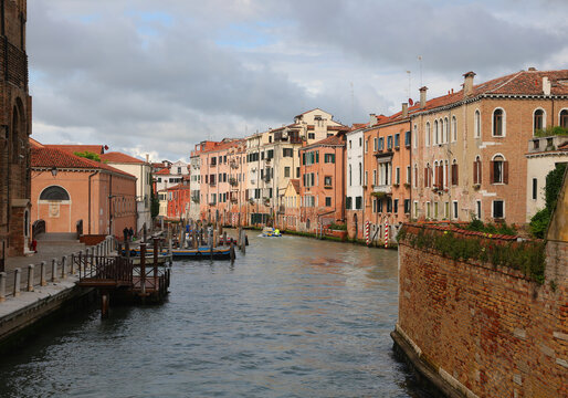 wide waterway with more moored boats and houses in Venice in Northern Italy