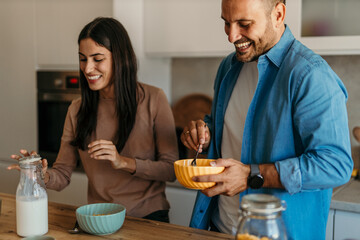 Happy couple enjoying breakfast together in modern kitchen