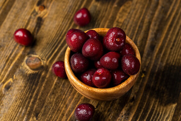 cherry in drops of water, wet red cherry fruits on the kitchen table close up, view from above