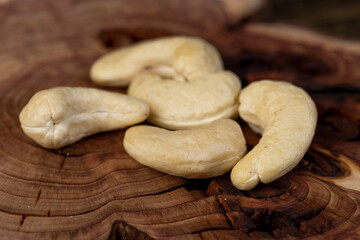 raw unroasted cashew nuts are healthy and allowed for vegans, nuts on a board made of pine side view