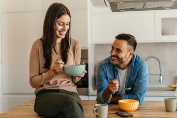 Happy couple enjoying breakfast together in modern kitchen