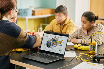 Students participating in interactive science lesson with a teacher guiding them. Educational tools and technology are used to enhance learning experience