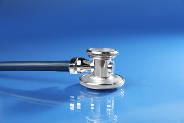 Stethoscope on blue background, closeup. Medical tool