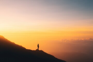 solitary figure stands on mountain peak beneath vast sky at sunrise