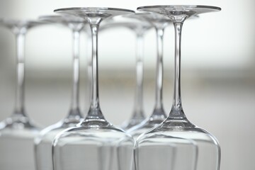 Upturned empty clean glasses on blurred background, closeup