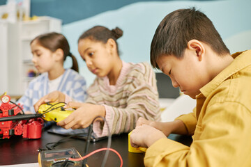 Children engaging in STEM activity with robotics kit, building and learning about technology in educational setting. Focused on hands-on learning and teamwork