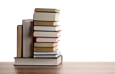 Many old books on wooden table against white background