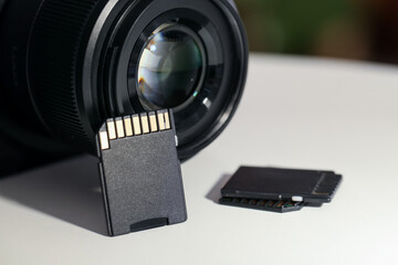 SD memory cards and photo camera on white table, closeup