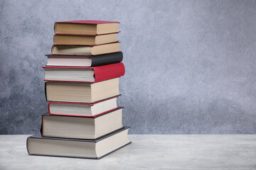 Old books on light grey table, space for text