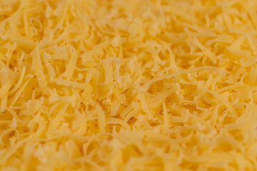 grated cheese of yellow color, grated cheese preparation for adding to dishes, close up