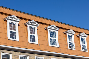 The top floor of a residential building. Row of windows of a house